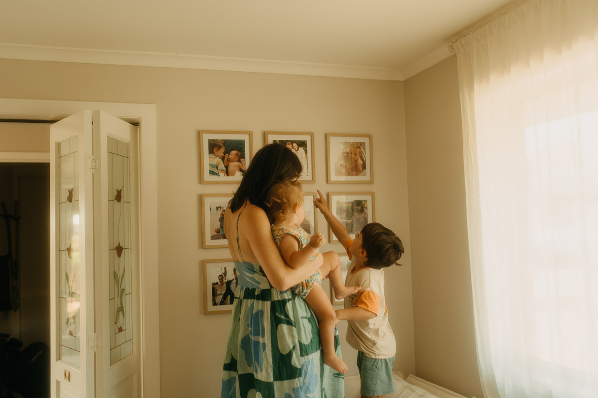 Mum cuddling her two young children on the living room couch during an unscripted Brisbane in-home photography session